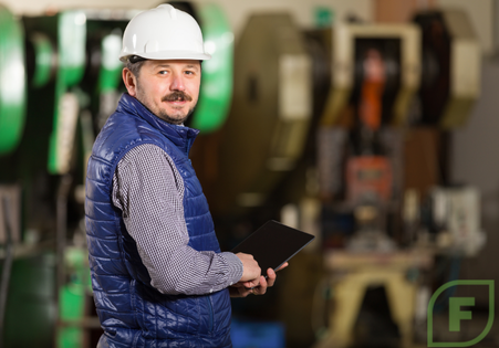 Small factory owner, overlooking machinery